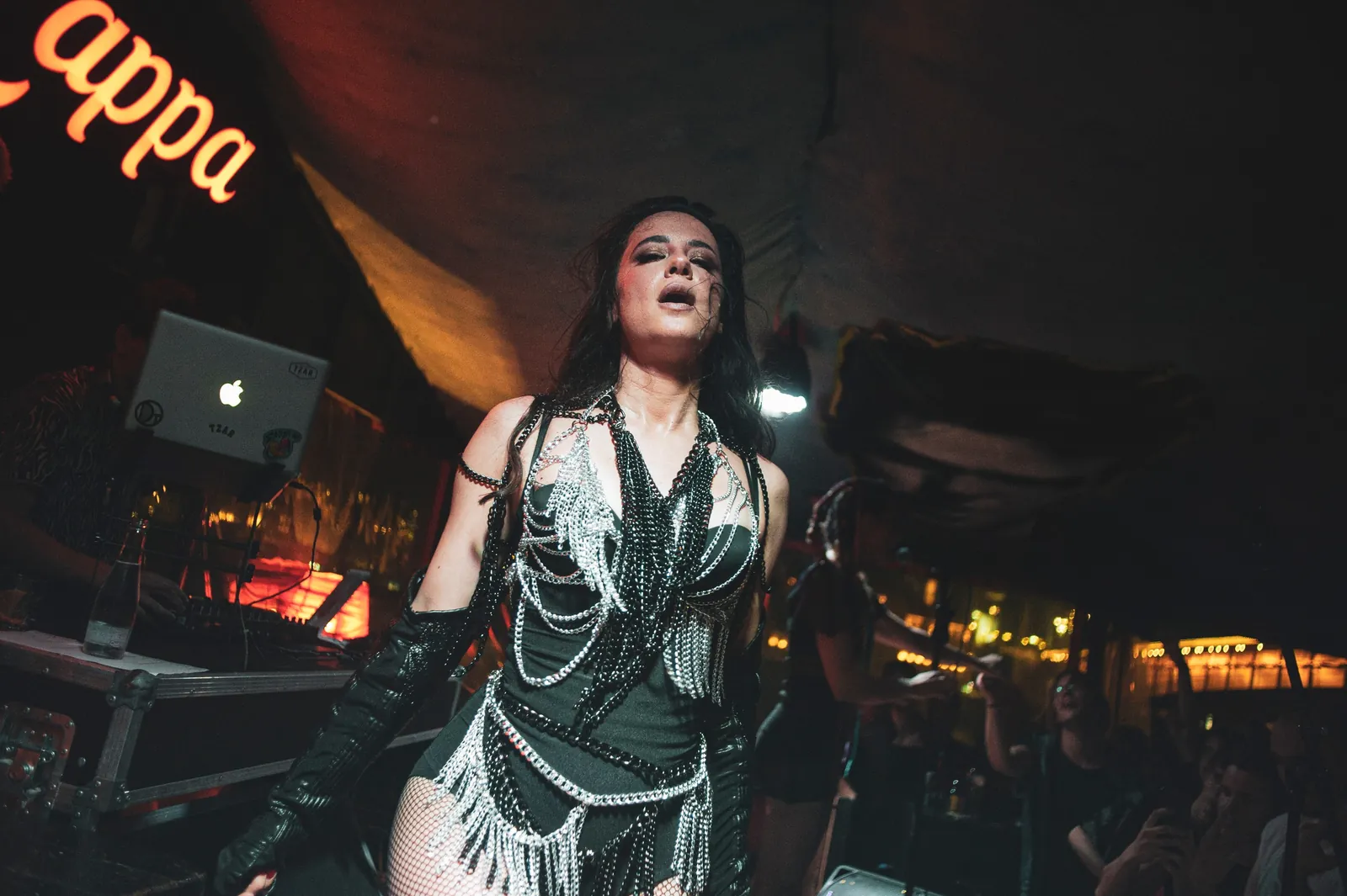 Sängerin im Ketten-Outfit bei einem vollen Clubkonzert