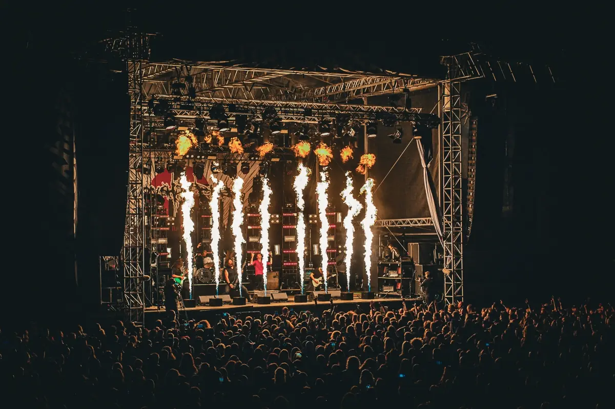 Pyrotechnik-Flammen über einer Festivalbühne bei Nacht